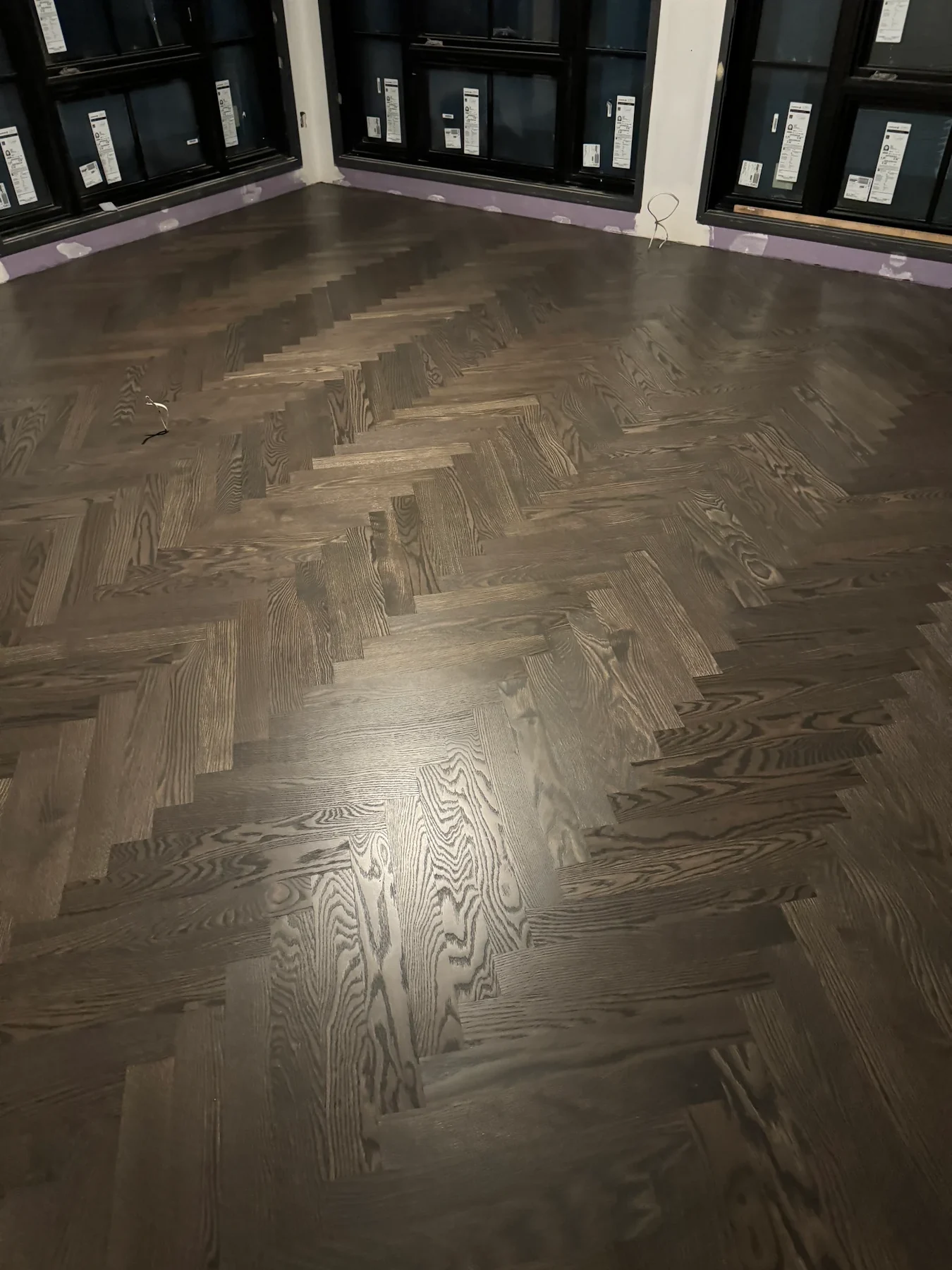 Dark stained herringbone hardwood floor installation